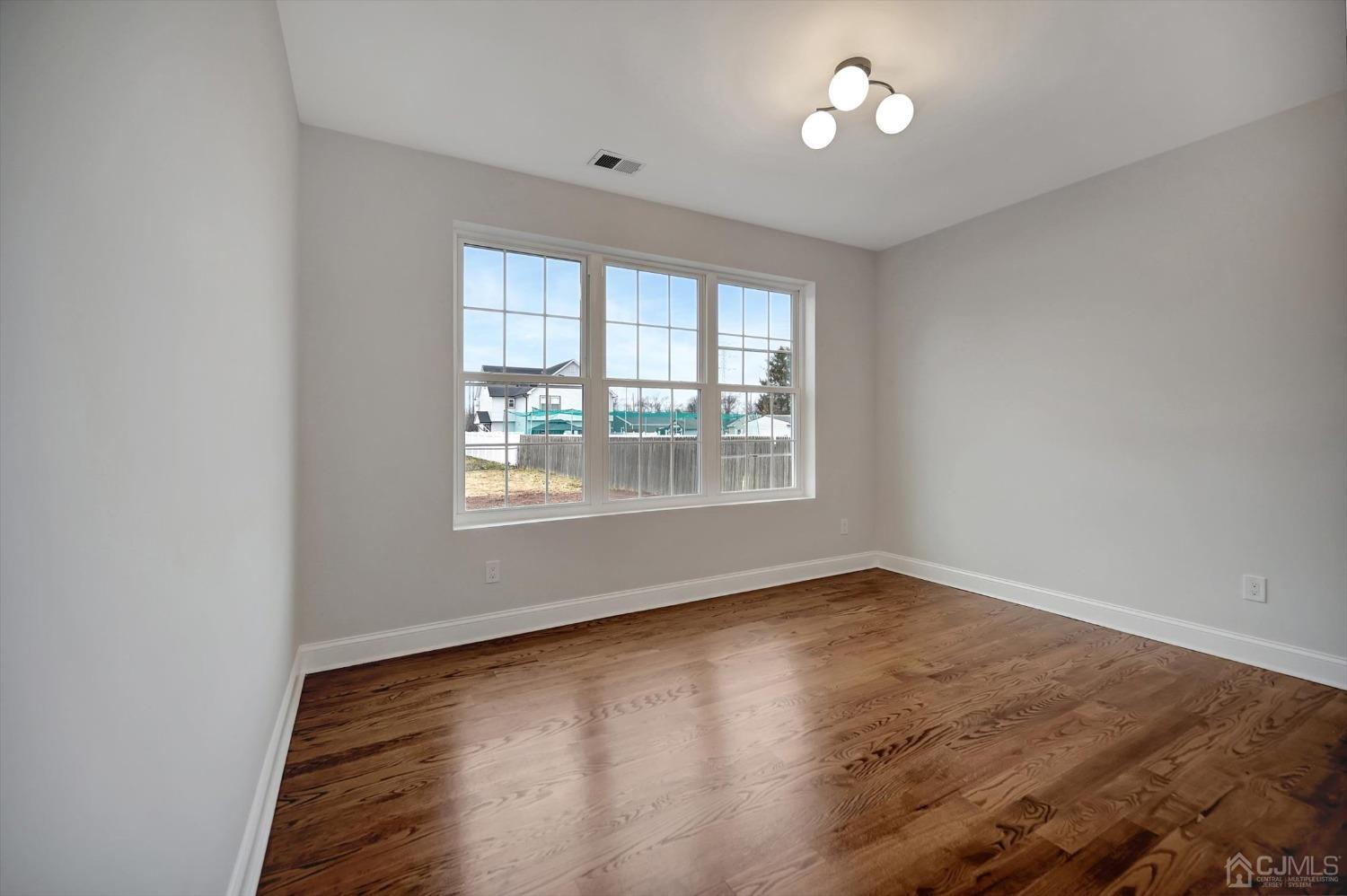 55 Walnut Street Edison, NJ 08817 - Photo 16 of 40 an empty room with wooden floor and windows