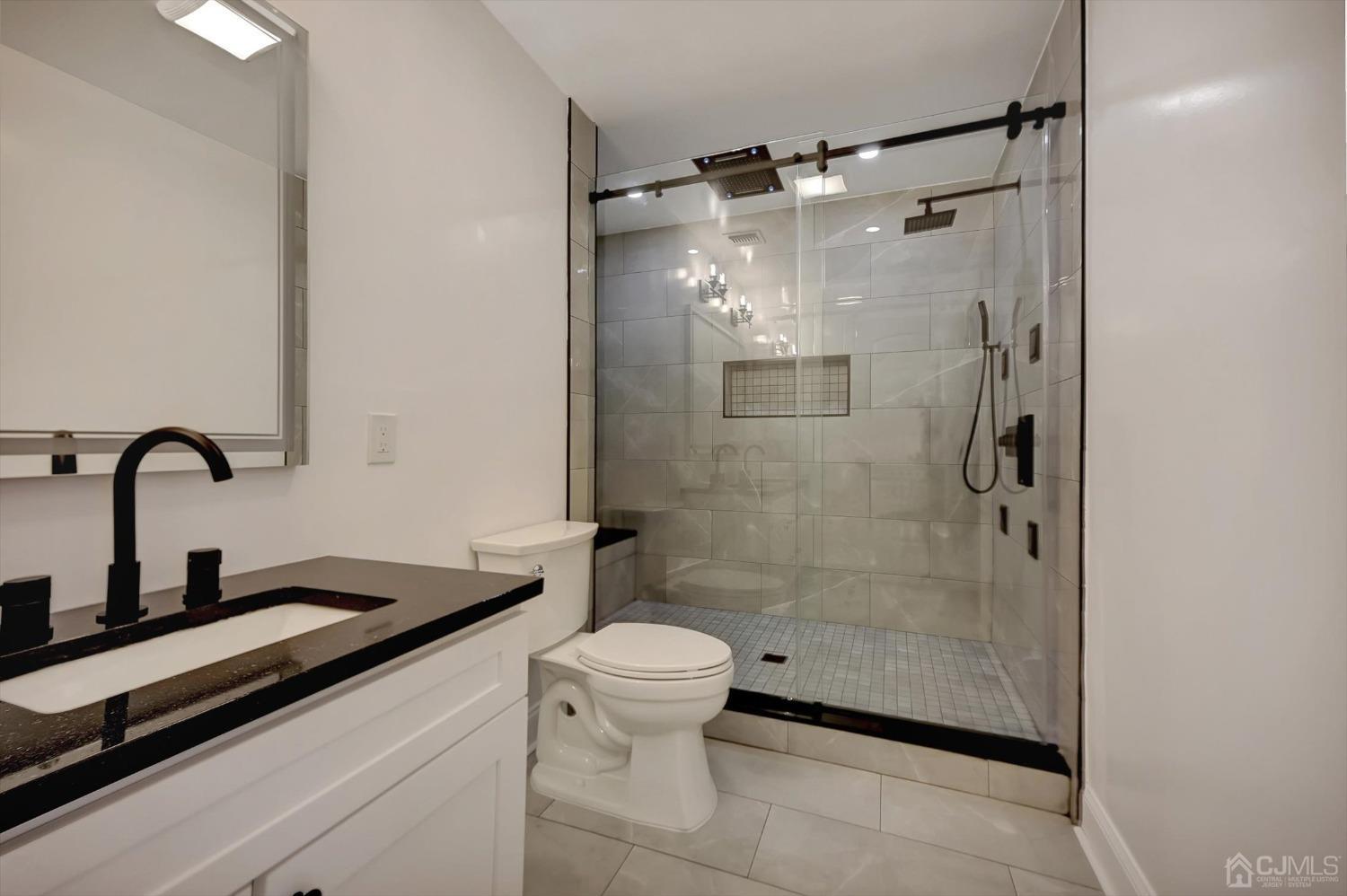 55 Walnut Street Edison, NJ 08817 - Photo 23 of 40 a bathroom with a shower sink vanity and toilet