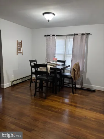 a view of a a dining room with furniture window and wooden floor