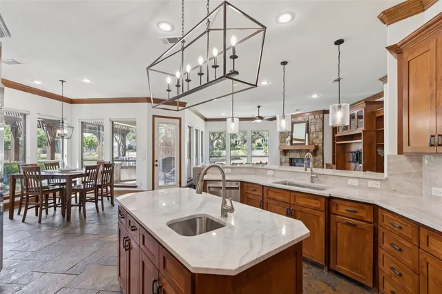 a kitchen with a stove a sink a kitchen island with chairs and wooden floor