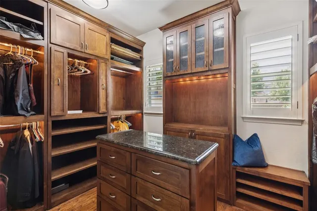 a view of walk in closet with clothes and shoes