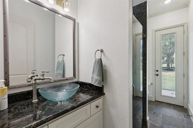 a bathroom with a granite countertop sink and a mirror