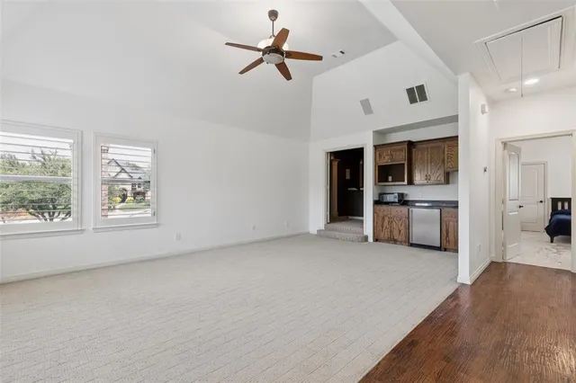 a view of a kitchen with a stove cabinets wooden floor and a ceiling fan