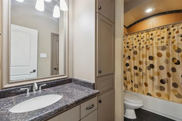 a bathroom with a granite countertop sink toilet and shower