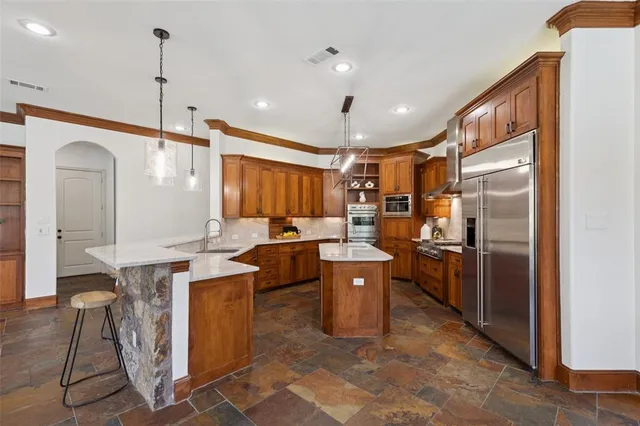 a kitchen with stainless steel appliances granite countertop a sink a stove and a refrigerator