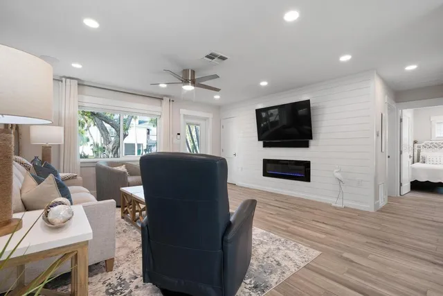 a living room with furniture a flat screen tv and a fireplace