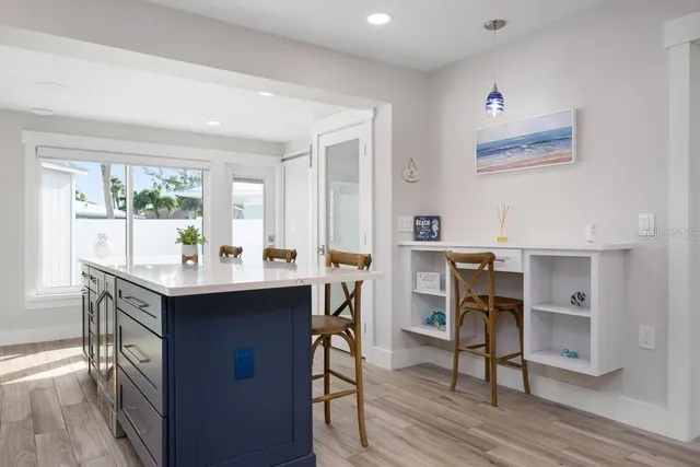 a kitchen with stainless steel appliances granite countertop a stove top oven a sink dishwasher a dining table and chairs with wooden floor