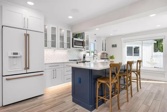 a kitchen with kitchen island a stove a sink and a refrigerator