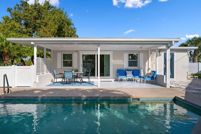 an aerial view of a city with lots of residential buildings and ocean view in back