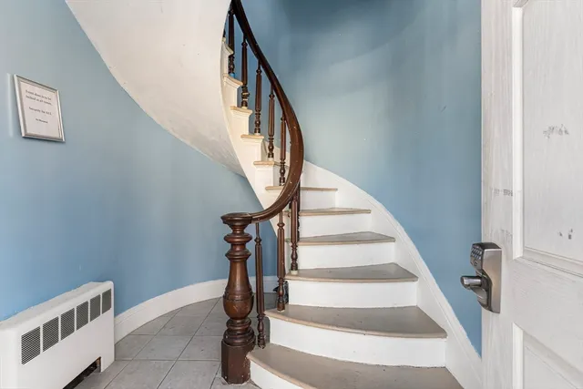 a view of staircase with wooden floor and white walls