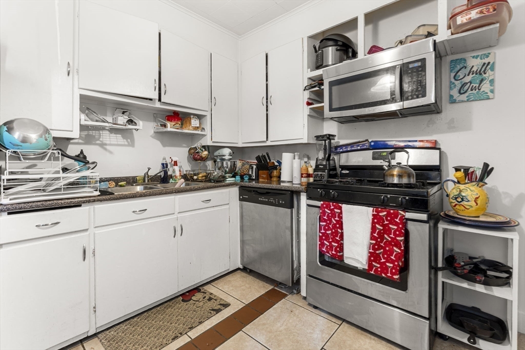 275 Bank Street Fall River, MA 02720 - Photo 9 of 20 a kitchen with stainless steel appliances granite countertop a stove a sink and a microwave