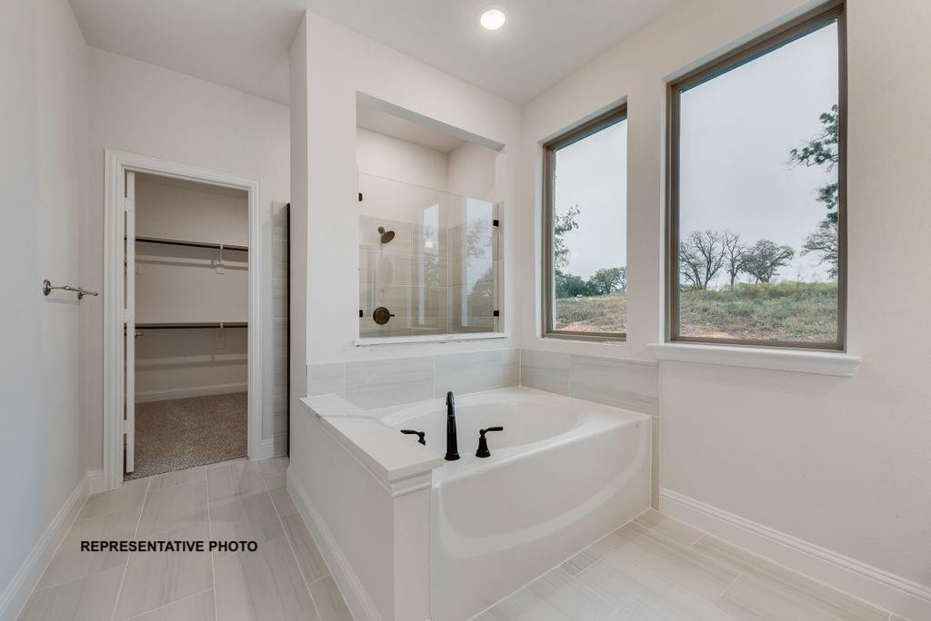 143 Rj Smith Drive Boyd, TX 76023 - Photo 12 of 21 a white bath tub sitting in a en suite bathroom next to a window