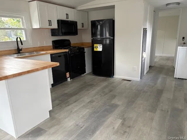 a kitchen with stainless steel appliances granite countertop a refrigerator a stove top oven a sink and dishwasher