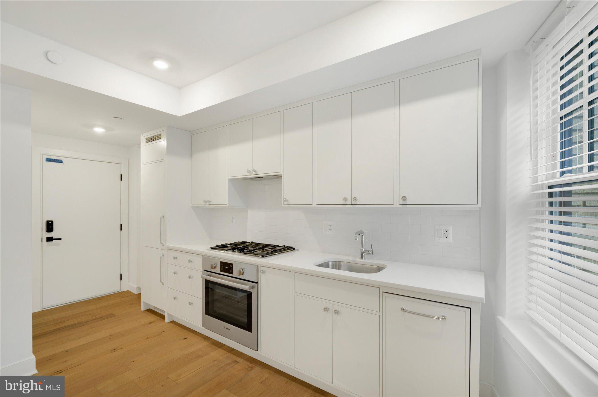 2869 28th Street Northwest, Unit 103 Washington, DC 20008 - Photo 12 of 19 a kitchen with granite countertop a sink stainless steel appliances and cabinets