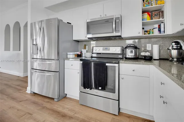 a kitchen with stainless steel appliances granite countertop a refrigerator stove and sink