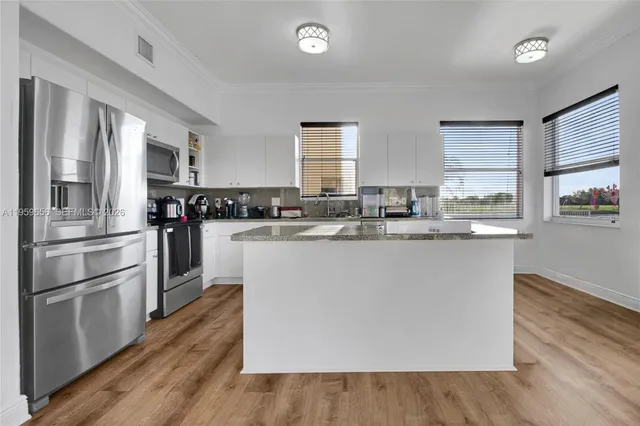 a kitchen with stainless steel appliances and wooden floor