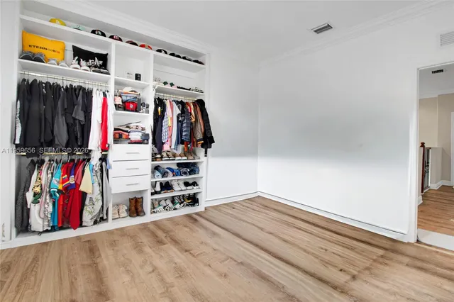 a view of walk in closet with clothes and shoes