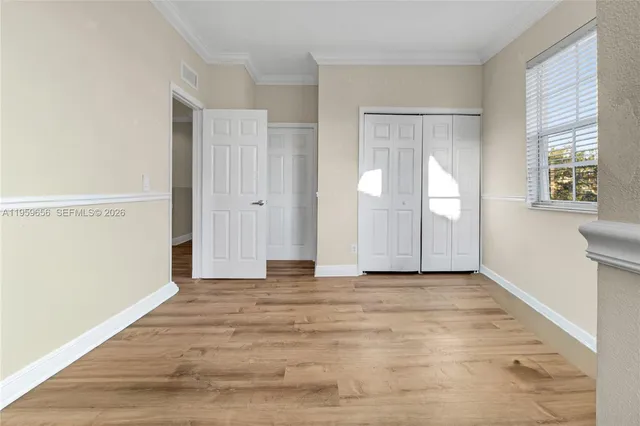 a view of an empty room with window and bathroom