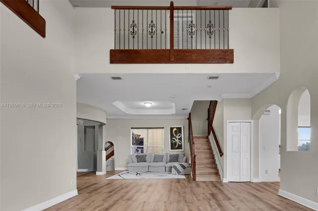 a view of a hallway with wooden floor and staircase