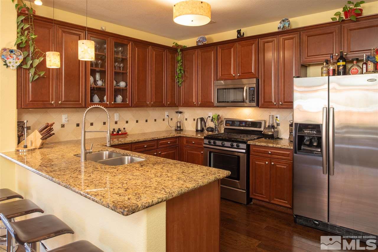 301 Manciano Way Reno, NV 89521 - Photo 4 of 20 a kitchen with kitchen island granite countertop a sink stove and refrigerator