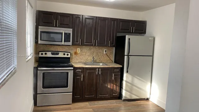 a kitchen with a refrigerator stove and microwave
