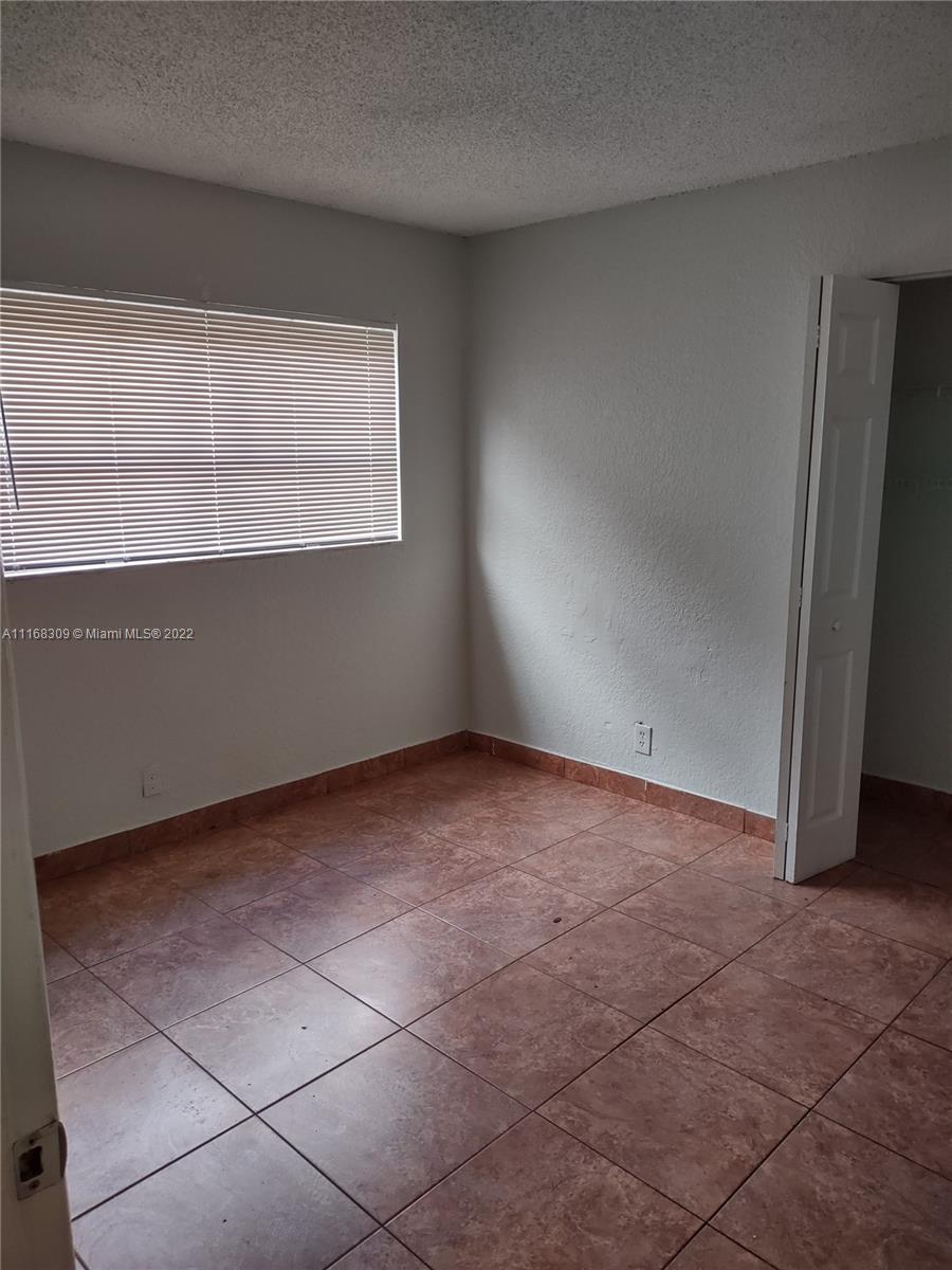 4445 Treehouse Lane, Unit A Tamarac, FL 33319 - Photo 11 of 16 a view of an empty room with a window