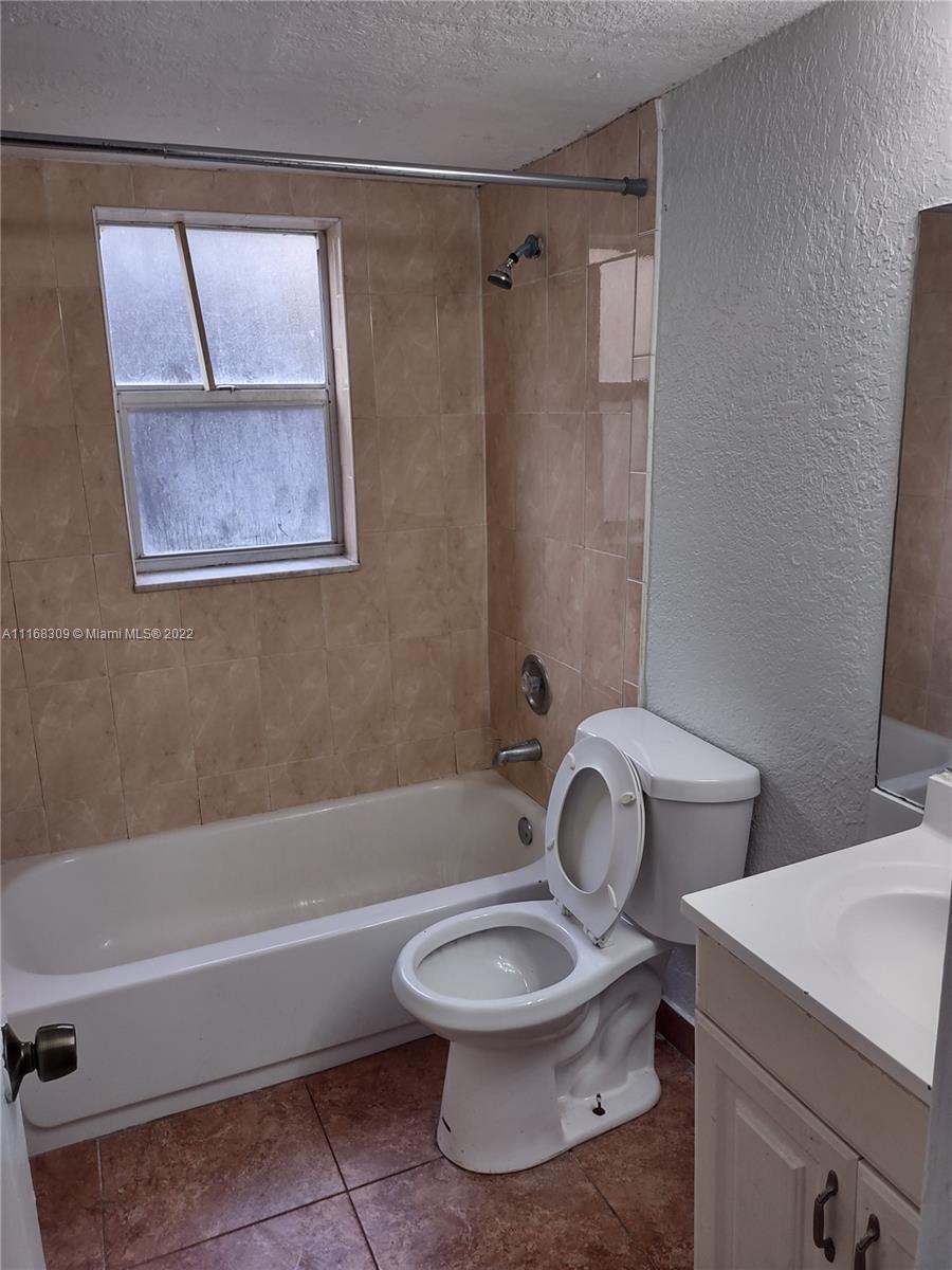 4445 Treehouse Lane, Unit A Tamarac, FL 33319 - Photo 13 of 16 a bathroom with a toilet and a bathtub