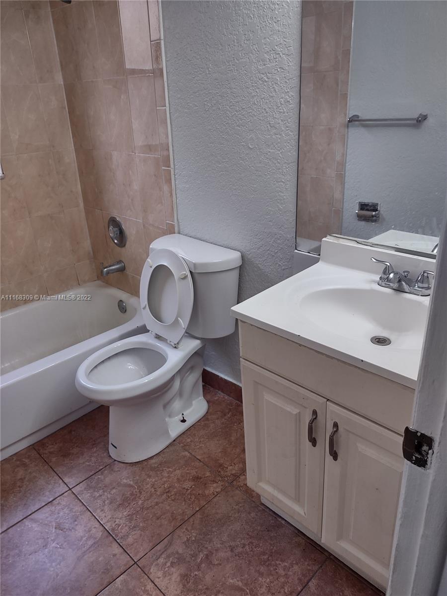 4445 Treehouse Lane, Unit A Tamarac, FL 33319 - Photo 14 of 16 a white toilet sitting next to a bathroom sink
