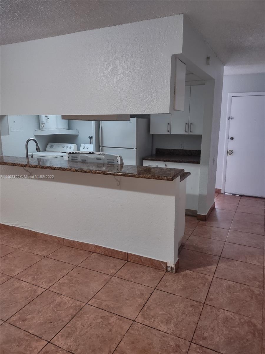 4445 Treehouse Lane, Unit A Tamarac, FL 33319 - Photo 4 of 16 a kitchen with a sink a stove and cabinets