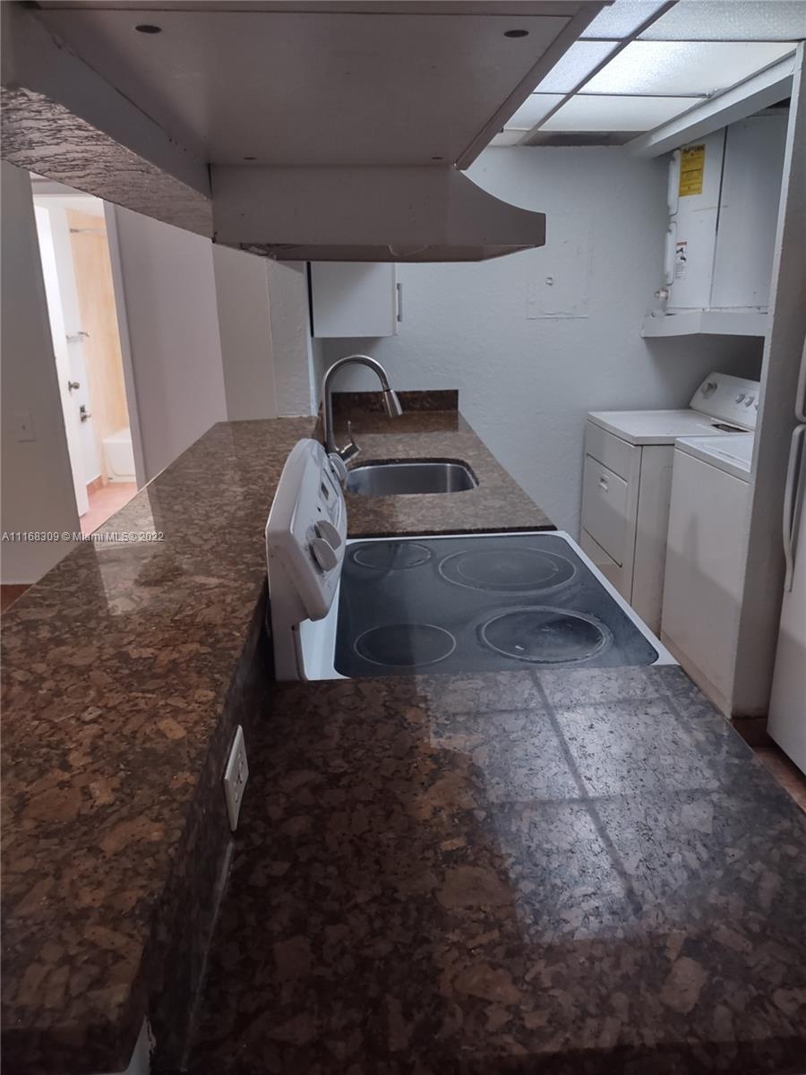 4445 Treehouse Lane, Unit A Tamarac, FL 33319 - Photo 7 of 16 a kitchen with a sink and cabinets