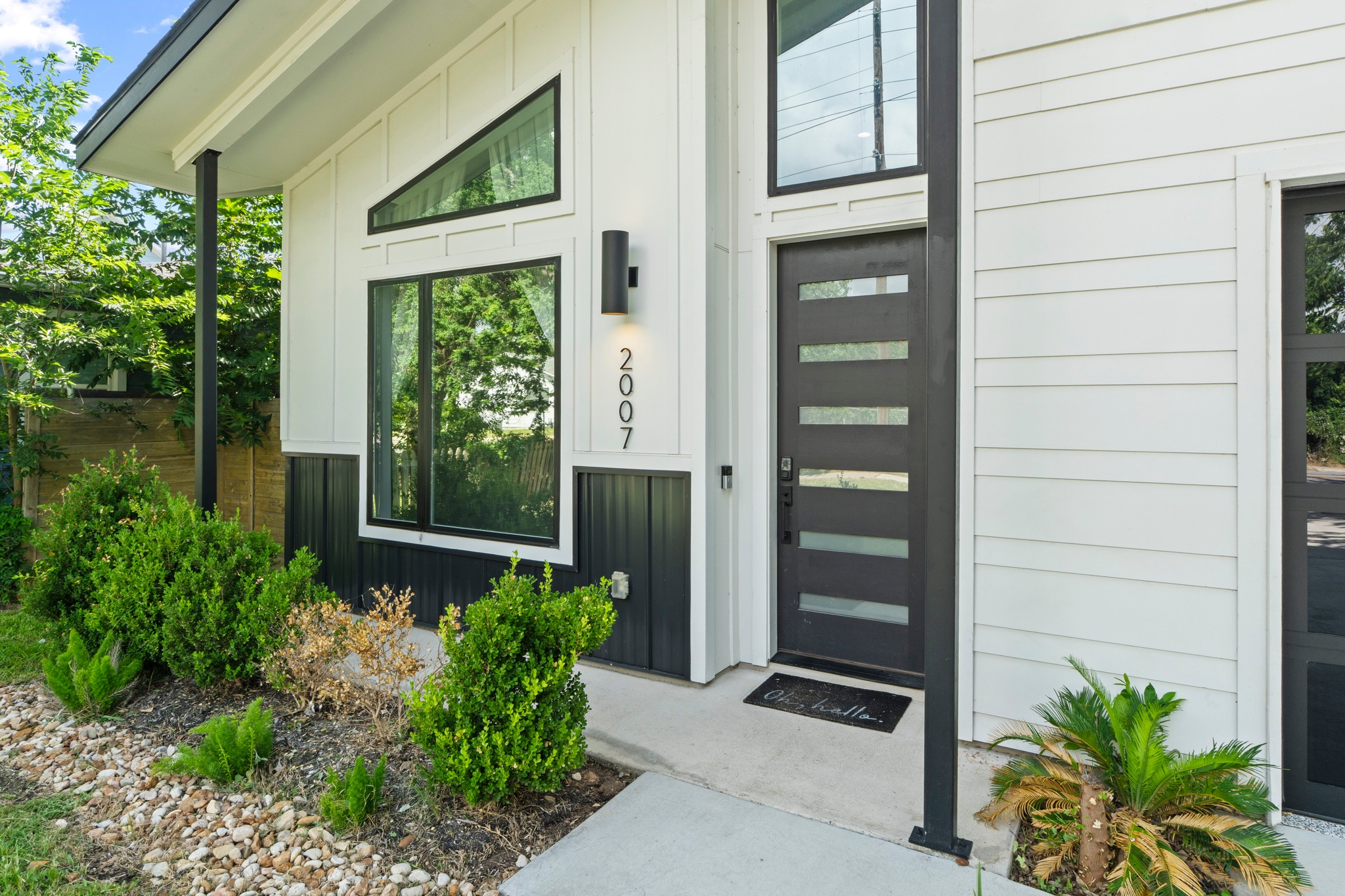 2007 Chestnut Avenue, Unit 1 Austin, TX 78722 - Photo 5 of 32 Bold black and white modern facade with angular windows and sleek entry.