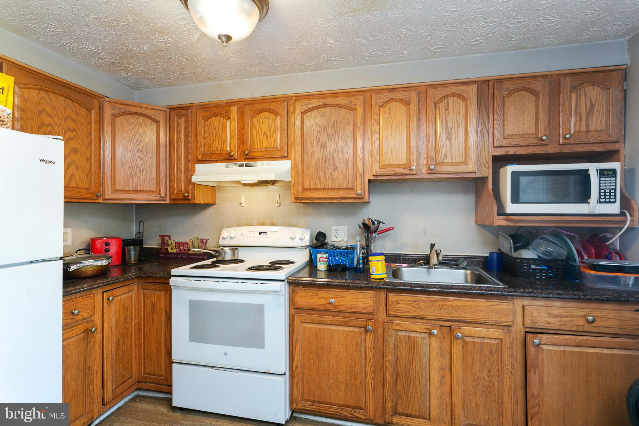 1217 Division Street Baltimore, MD 21217 - Photo 3 of 14 a kitchen with stainless steel appliances granite countertop a stove a sink dishwasher and cabinets with wooden floor