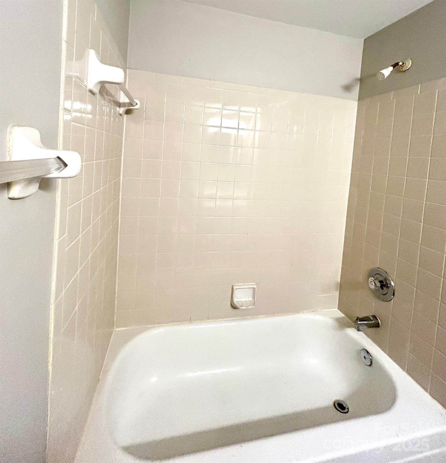 9401 Old Concord Road, Unit A Charlotte, NC 28213 - Photo 11 of 12 a bathroom with a white bath tub a shower and a sink
