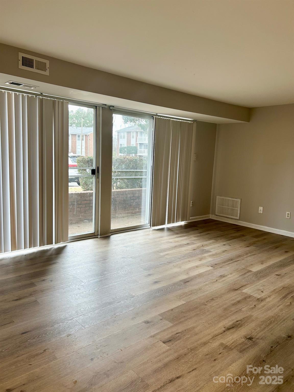 9401 Old Concord Road, Unit A Charlotte, NC 28213 - Photo 4 of 12 an empty room with wooden floor and windows