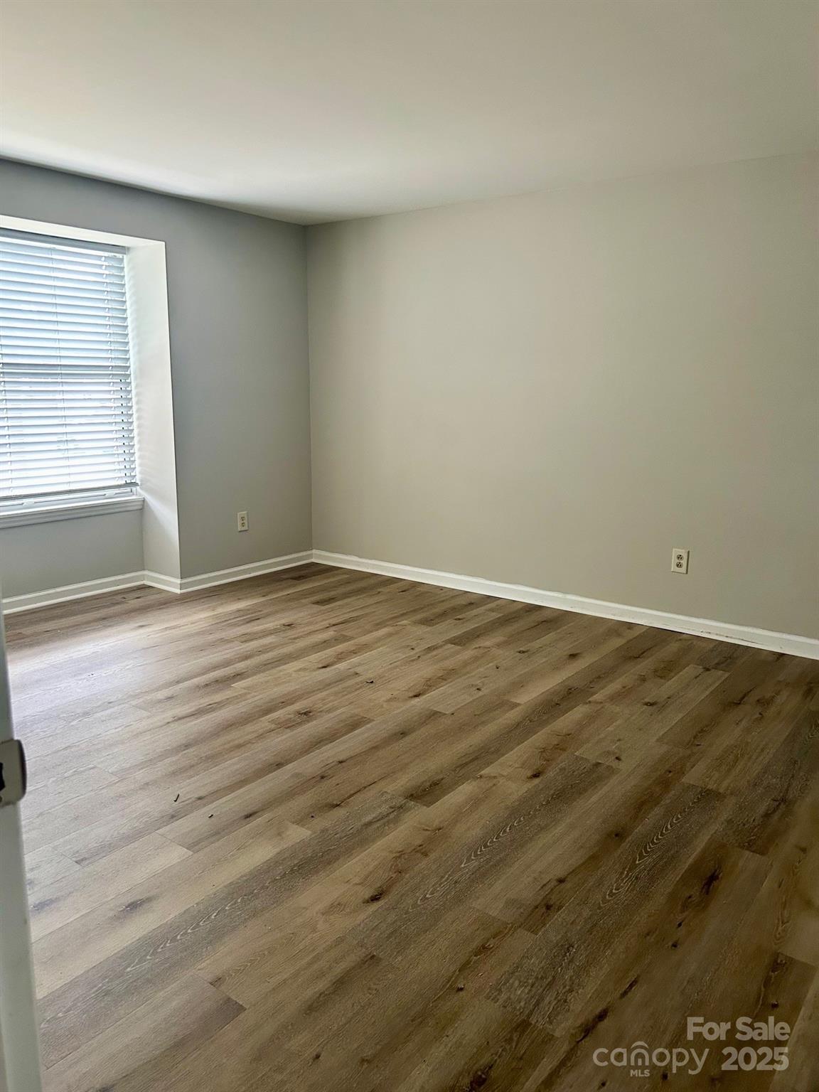 9401 Old Concord Road, Unit A Charlotte, NC 28213 - Photo 9 of 12 an empty room with wooden floor and windows
