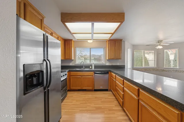 a kitchen with stainless steel appliances granite countertop a sink and a refrigerator