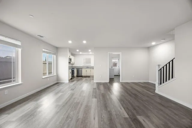a view of empty room with wooden floor and windows