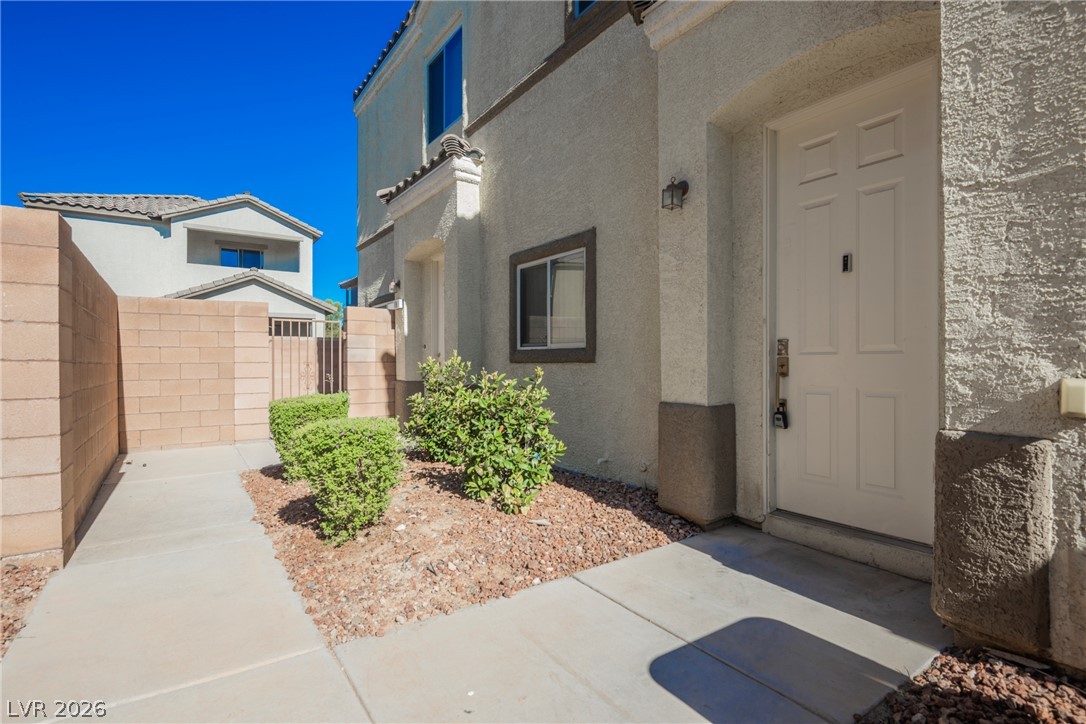6320 Snap Ridge Street, Unit 201 North Las Vegas, NV 89081 - Photo 51 of 56 A welcoming front entrance features desert-friendly landscaping, a walled yard, and a clean concrete pathway.