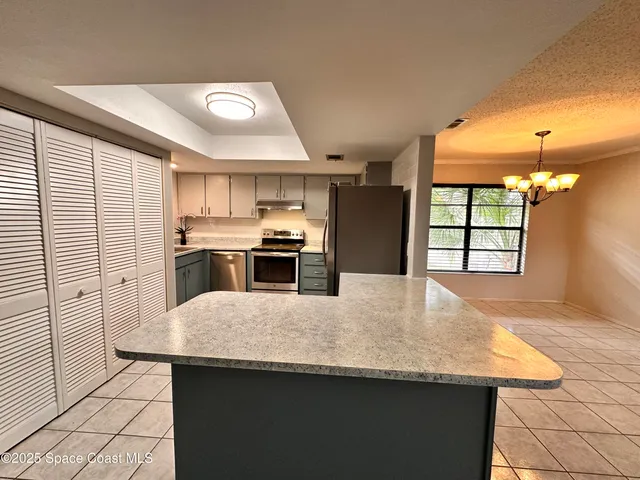 a kitchen with kitchen island a sink stainless steel appliances and window