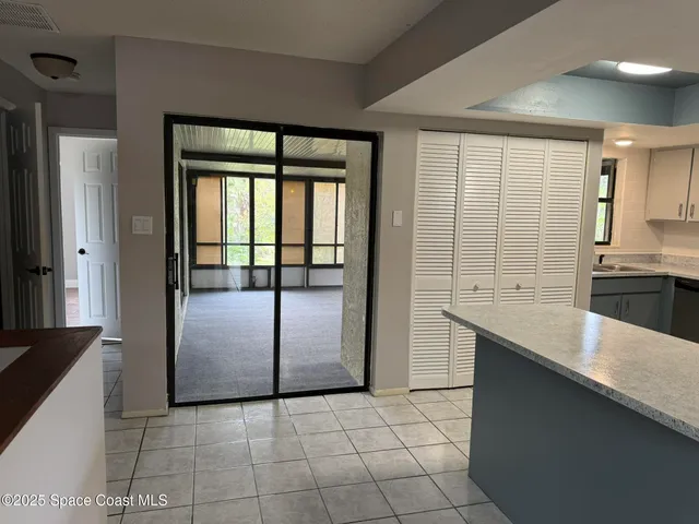 a kitchen with granite countertop a refrigerator a sink and white cabinets