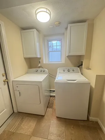 a view of an empty room with chandelier fan and wooden floor