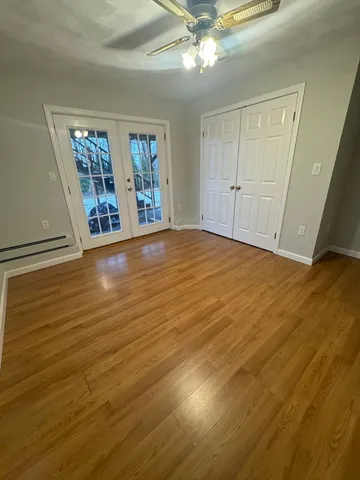 a view of an empty room with window and wooden floor