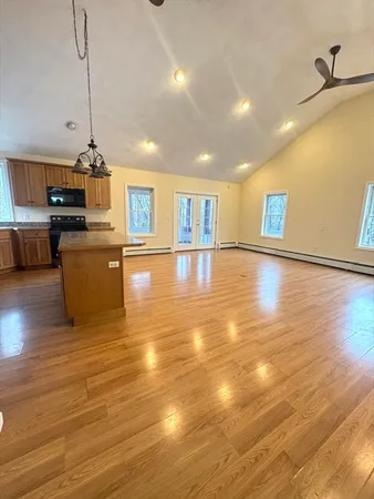 a view of a living room a kitchen island wooden floor and window