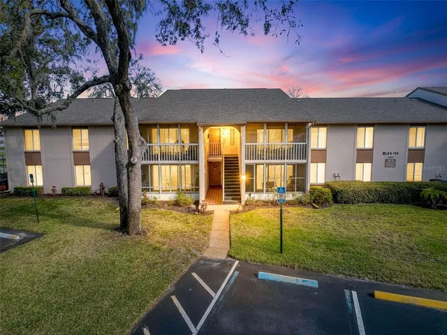 a view of a house with backyard and sitting area