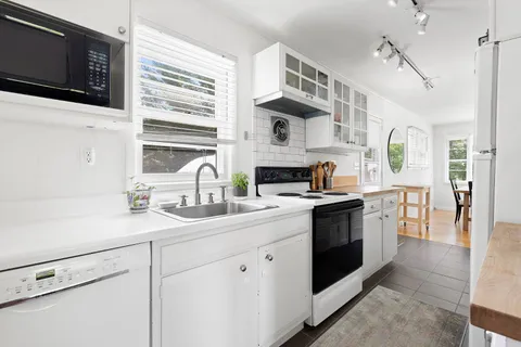 a kitchen with stainless steel appliances granite countertop a sink a stove and a microwave