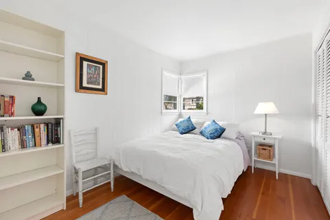 a bedroom with a bed and a lamp on dresser