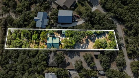 an aerial view of a house with a yard and lake view