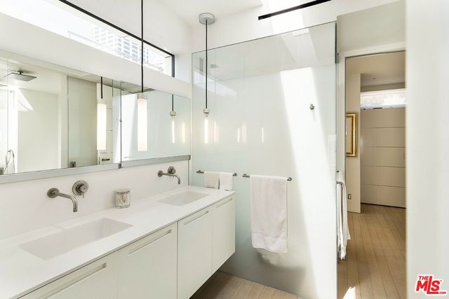 a bathroom with a double vanity sink a mirror and shower