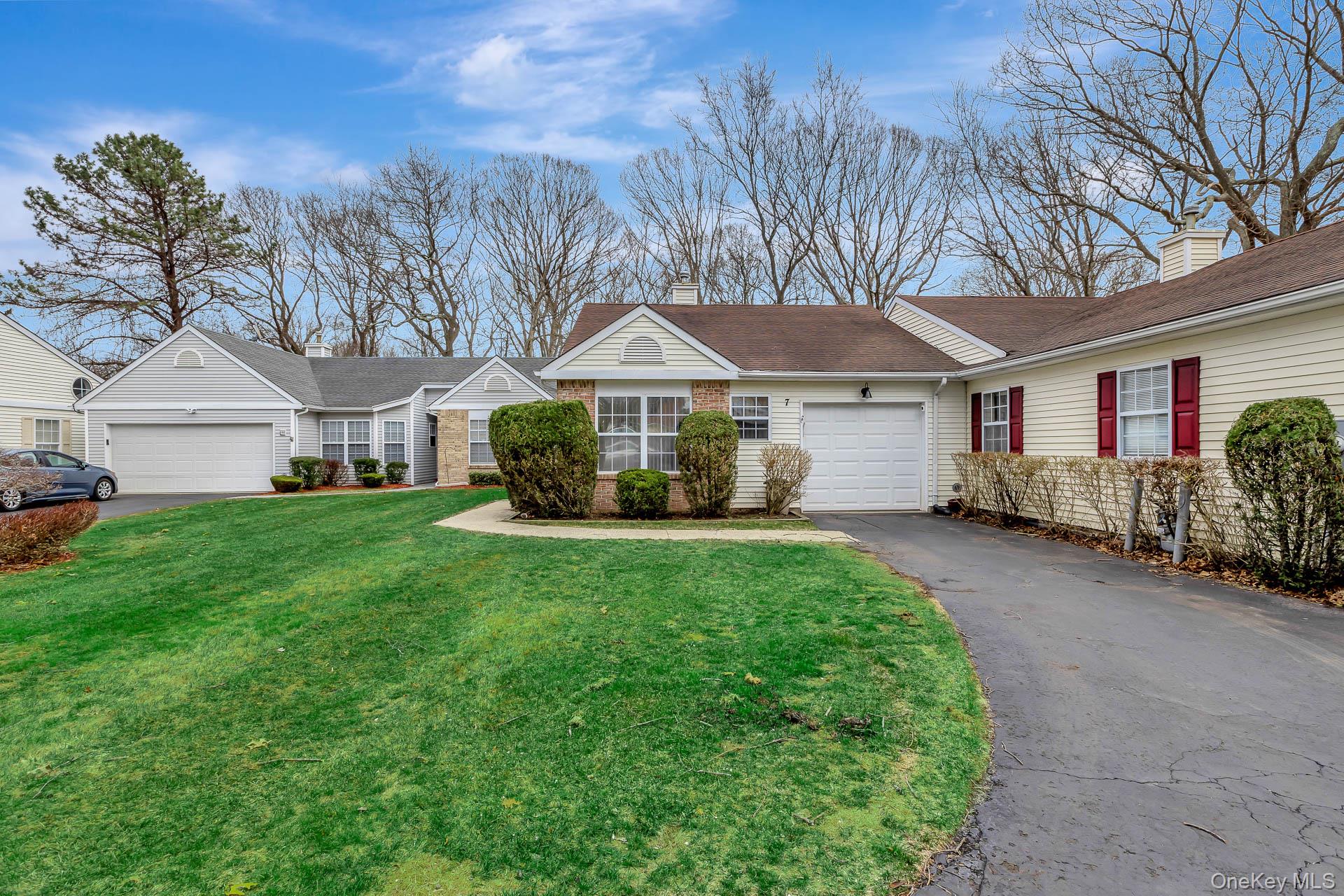 7 Possum Path Coram, NY 11727 - Photo 3 of 22 a front view of a house with a garden and trees