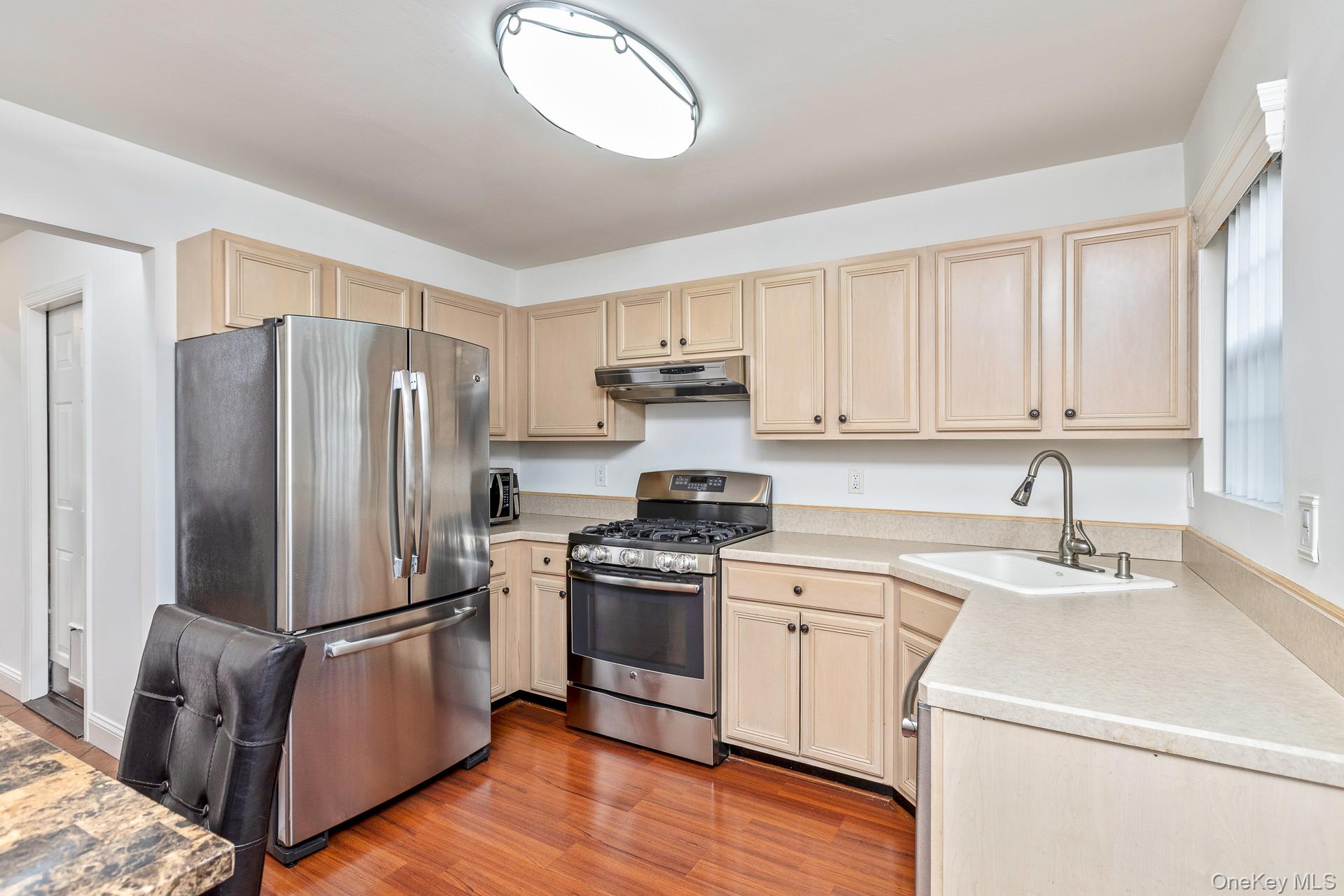 7 Possum Path Coram, NY 11727 - Photo 9 of 22 a kitchen with a refrigerator stove and wooden cabinets